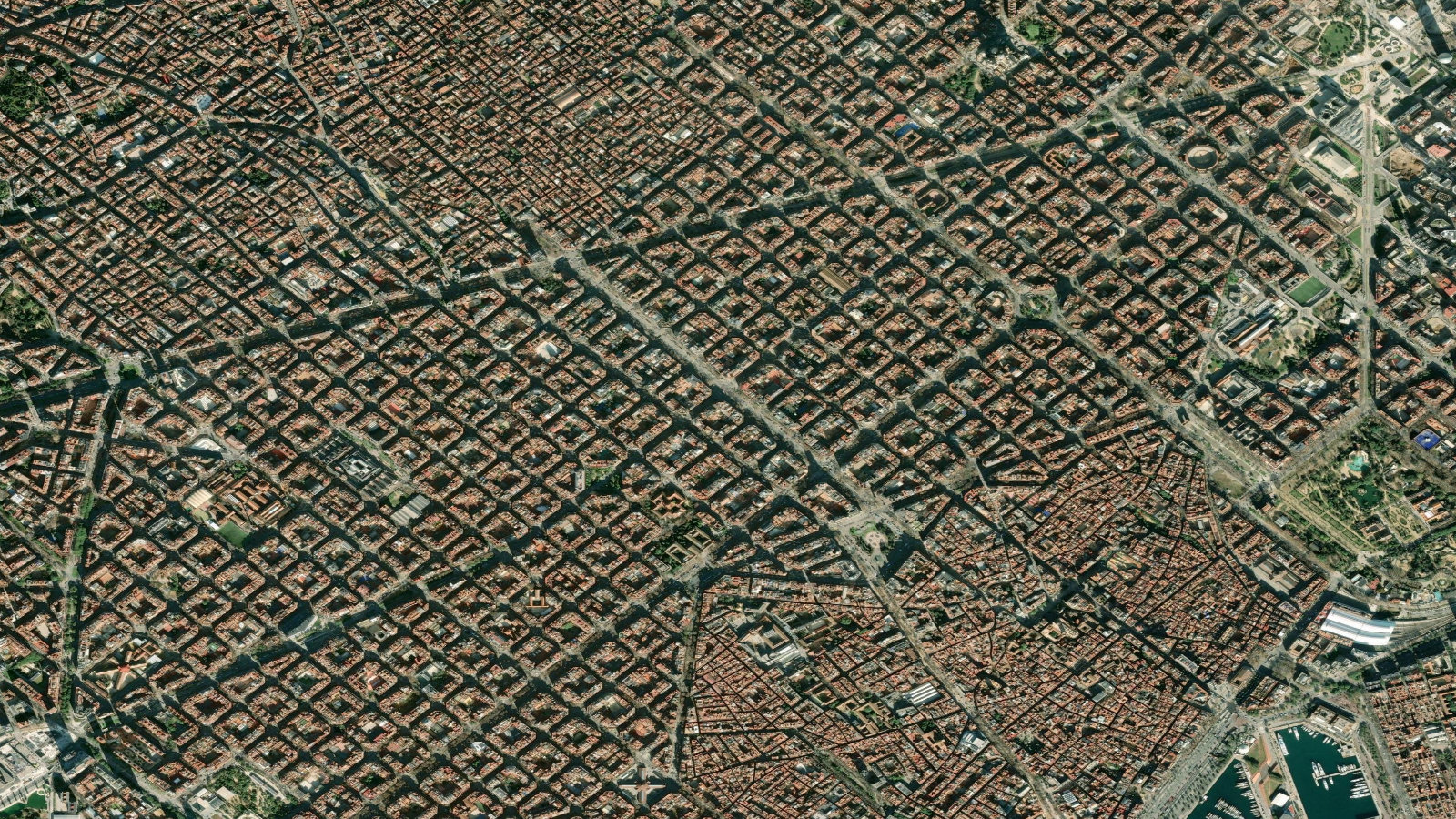 Satellite view of Barcelona's Eixample district, its octagonal city blocks in a regular grid, with the old town and port at the edge.
